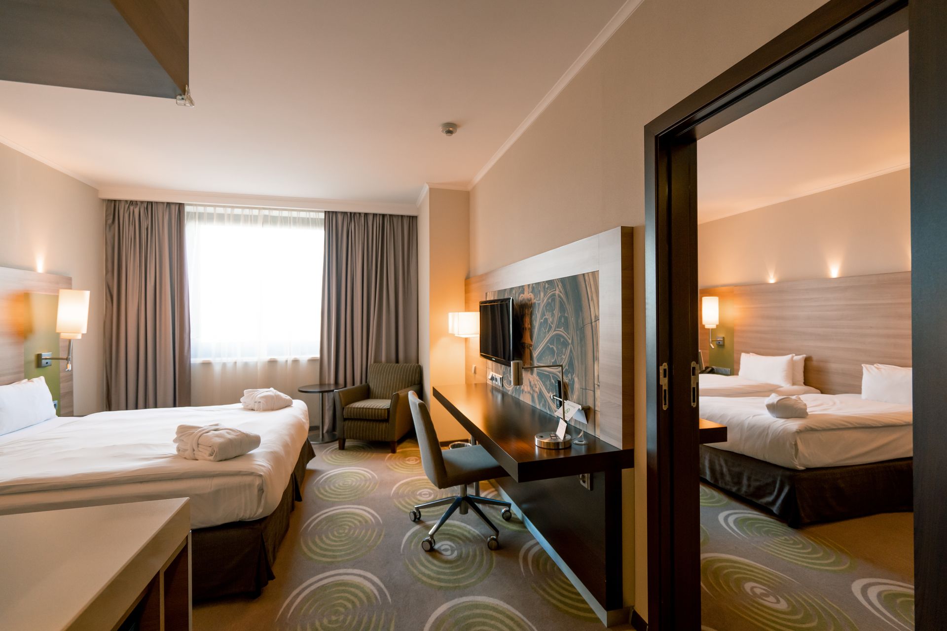 Chambre d'hôtel avec lit double place et coin bureau avec téléviseur