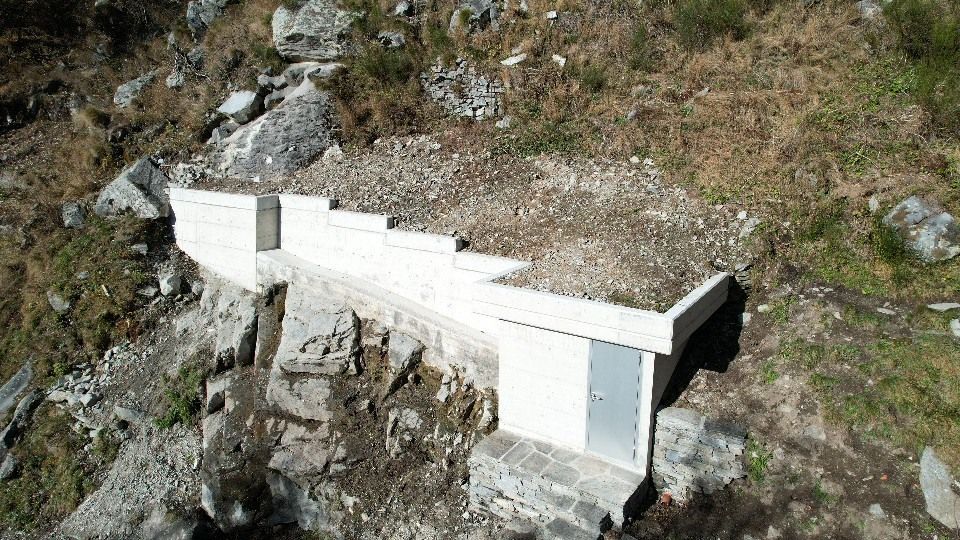 Tettisti al lavoro su un tetto complesso con struttura in legno, grondaie in rame e camini in mattoni.