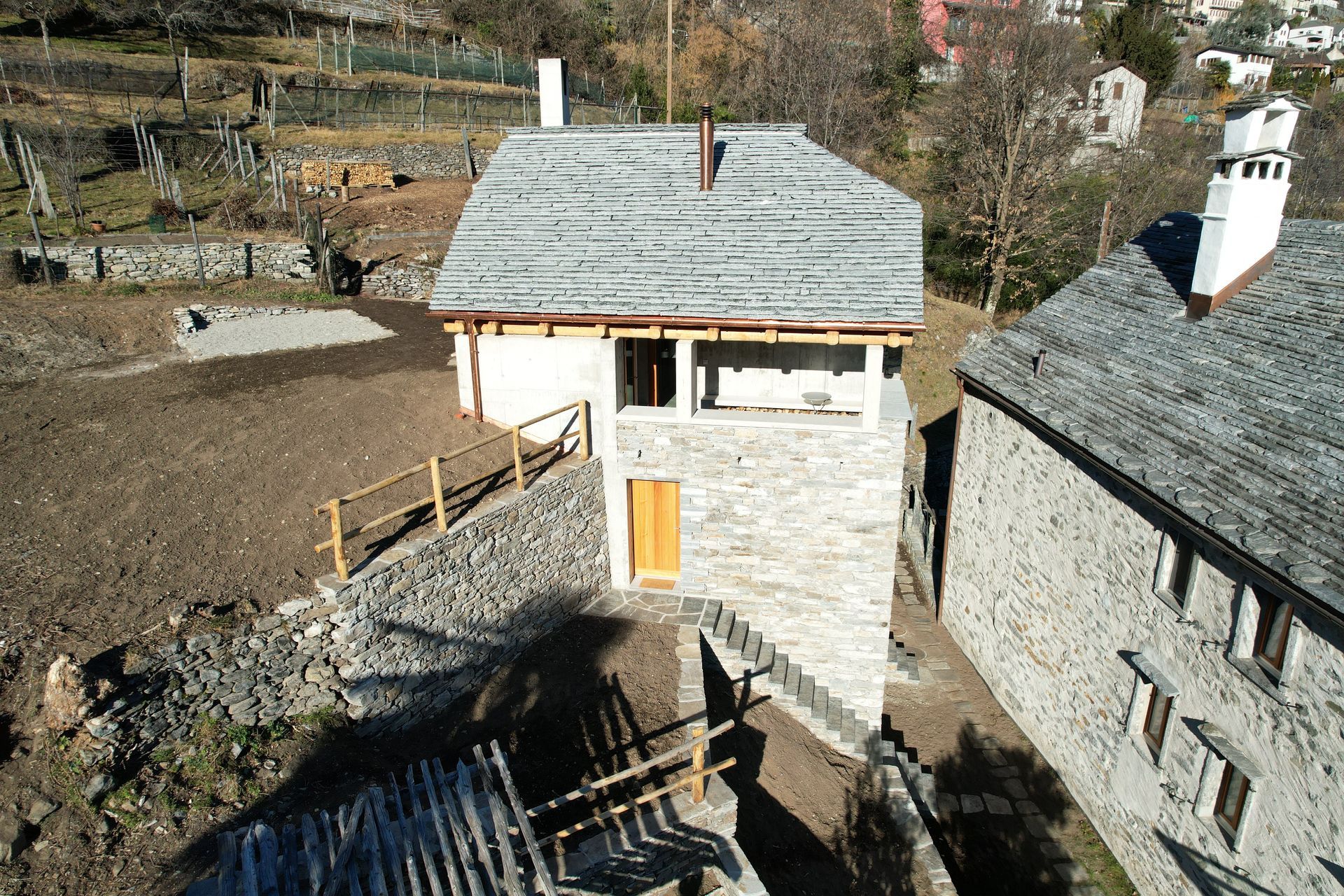 Tettisti al lavoro su un tetto complesso con struttura in legno, grondaie in rame e camini in mattoni.