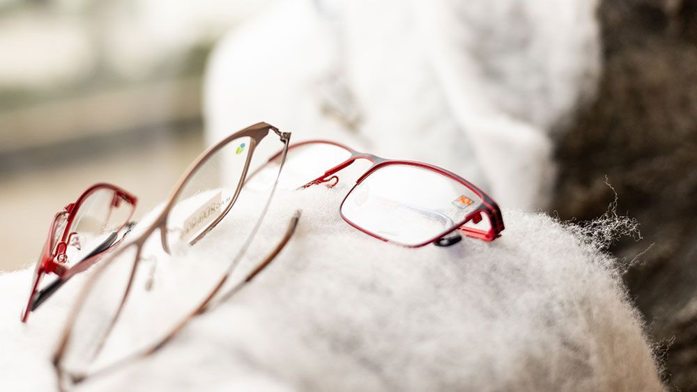 Eine Brille, die auf einem weißen Tuch liegt.