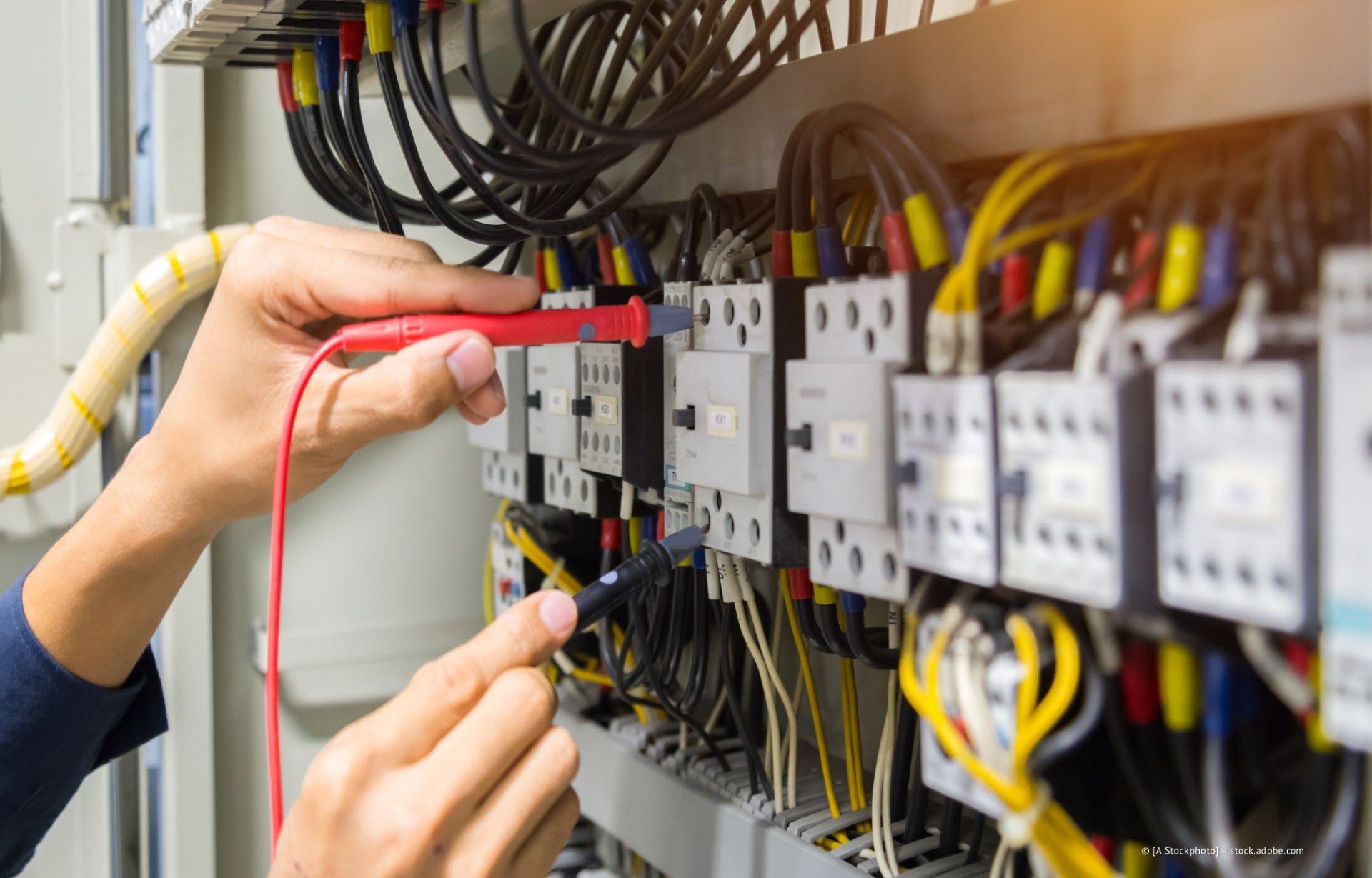Manuelles Anschließen von Drähten an einen elektrischen Schaltschrank mit Relais und Leistungsschaltern
