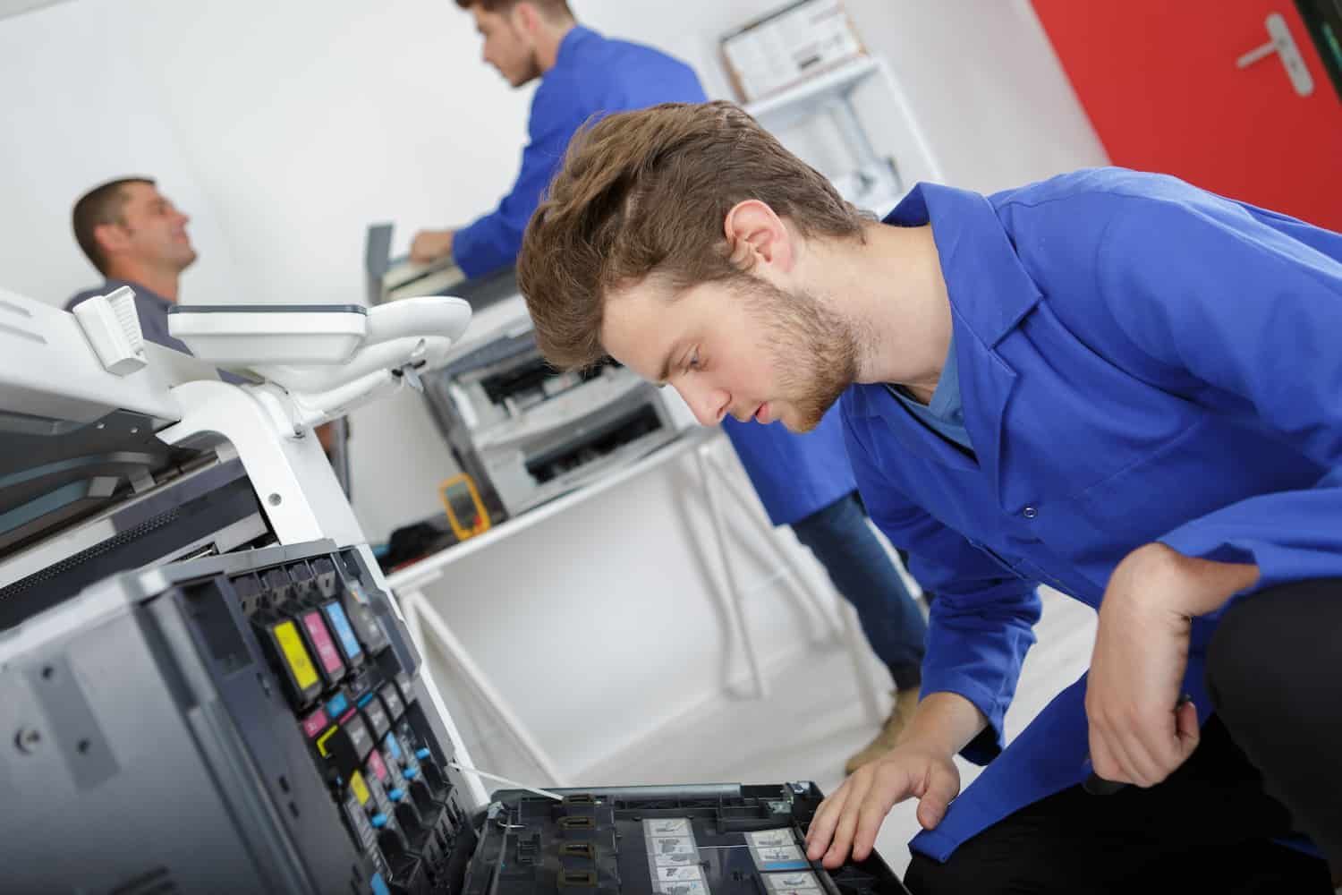 Ouvrier qui répare une imprimante