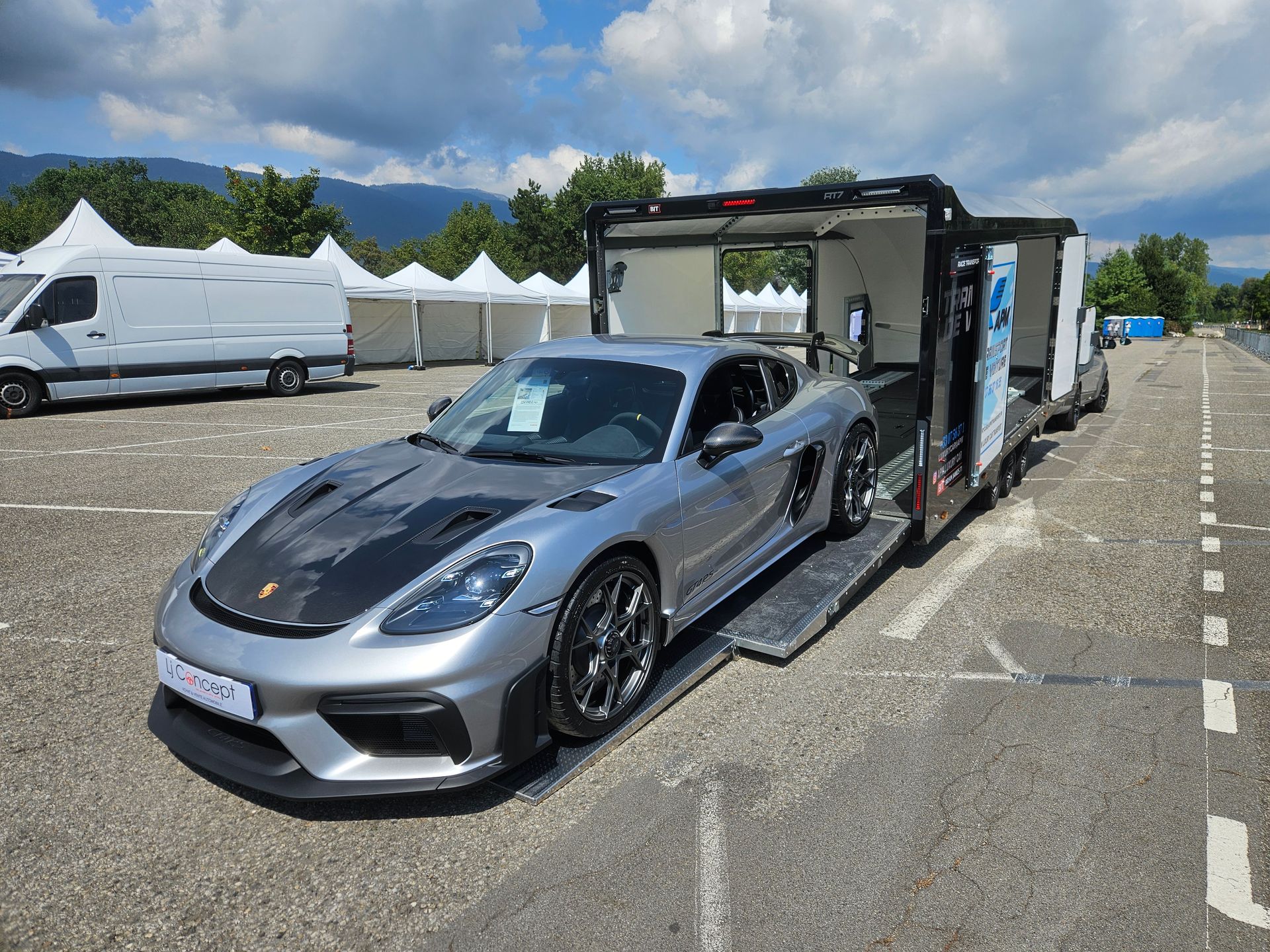 Une Porsche sport avec un capot en fibre de carbone est garée sur la rampe de chargement d'une remorque de transport.