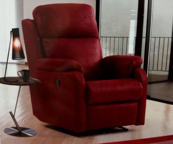 Un sillón reclinable rojo en una sala de estar junto a una mesa pequeña.