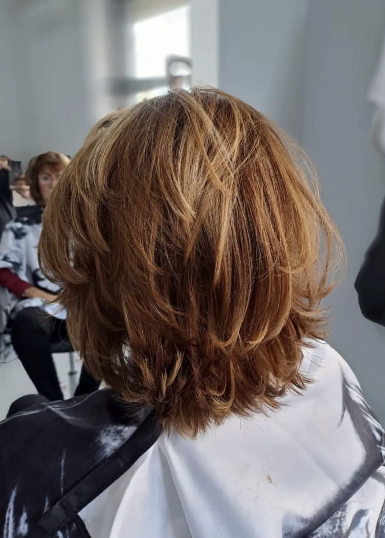 Una mujer se está cortando el pelo en una peluquería.