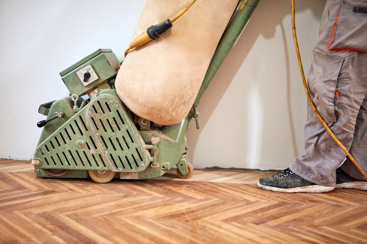 Ouvrier ponçant le parquet avec un équipement