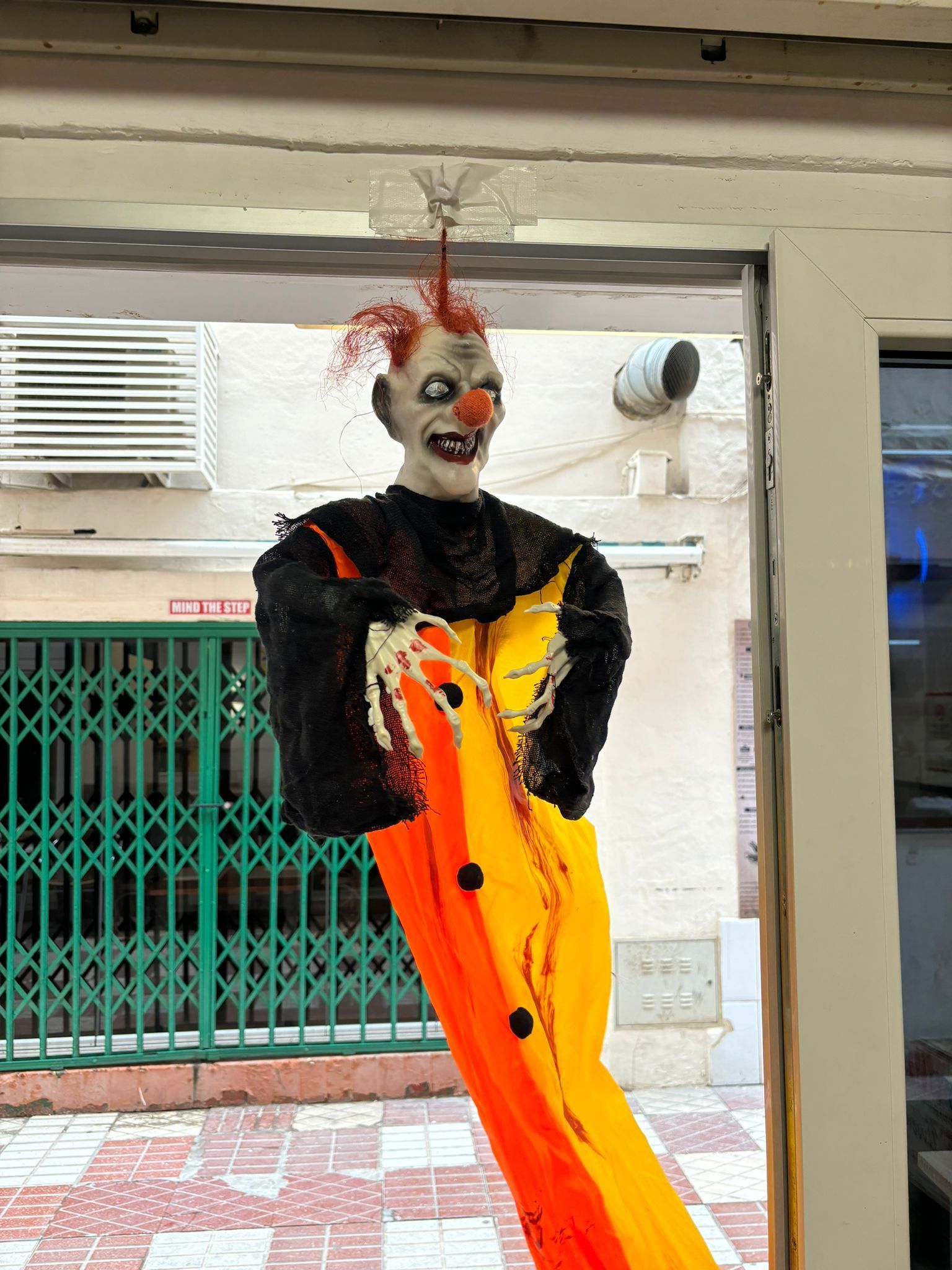 Un payaso aterrador cuelga del techo de un edificio.
