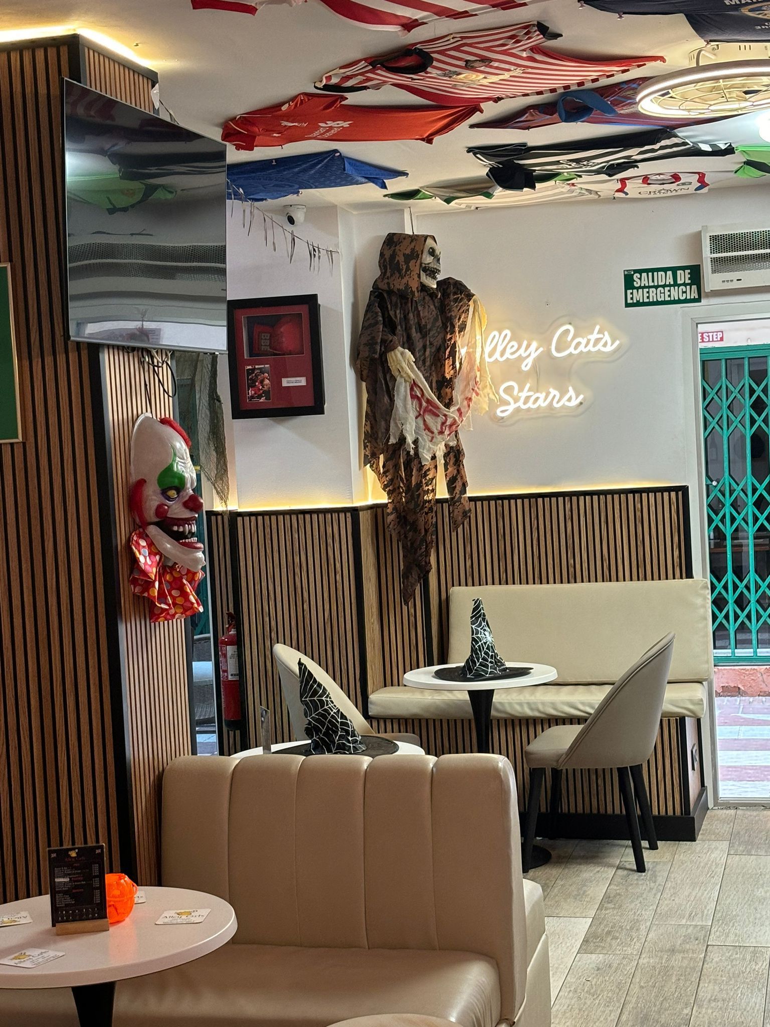 Un restaurante con mesas y sillas y un letrero de neón en el techo.