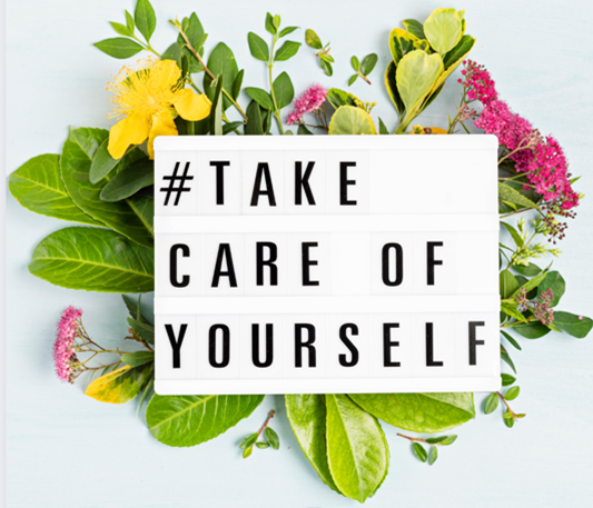 A sign that says take care of yourself is surrounded by flowers and leaves