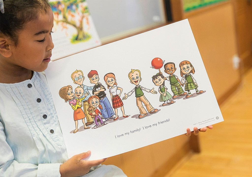 A little girl is holding a picture of a group of people holding hands.