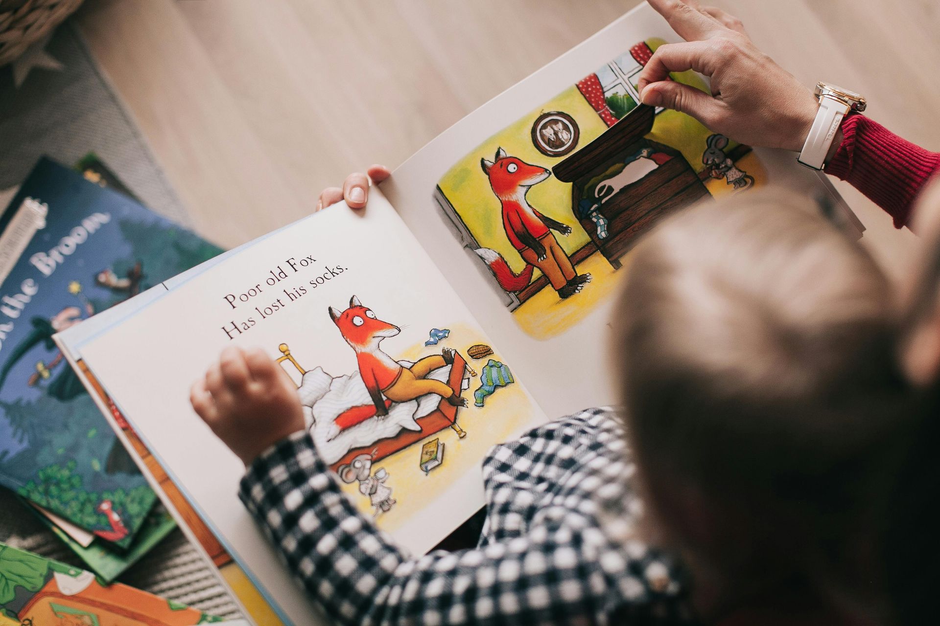 A person is reading a book to a child.