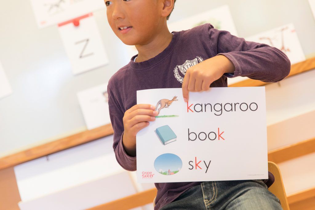 A young boy is holding a sign that says kangaroo book sky