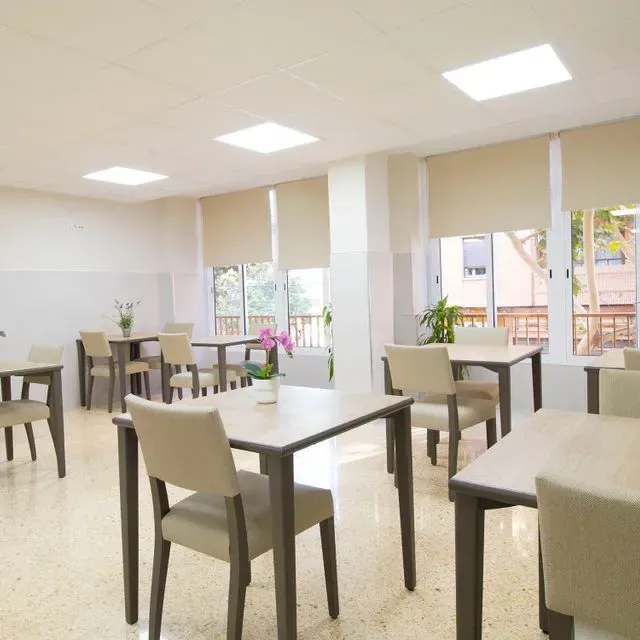 Una habitación con mesas y sillas y una ventana.