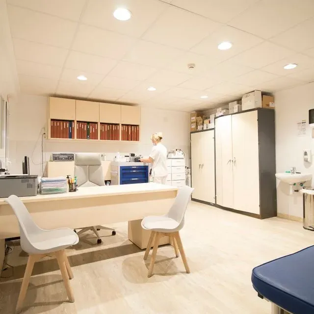 Una enfermera está de pie en un escritorio en una oficina.