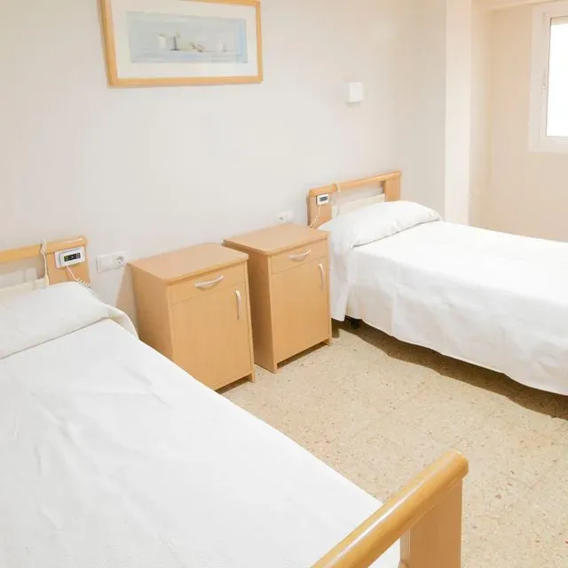 Un dormitorio con dos camas y un cuadro en la pared.