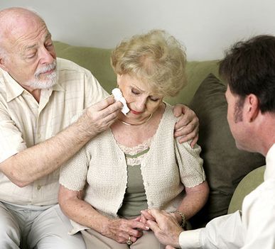 Un hombre está consolando a una anciana que está llorando.