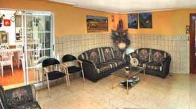 Una sala de estar con un sofá, sillas y una mesa.