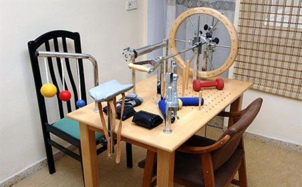 Una mesa de madera con sillas y equipo de ejercicio sobre ella.