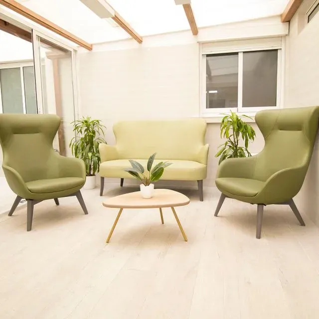 Una sala de estar con sillas verdes y un sofá.