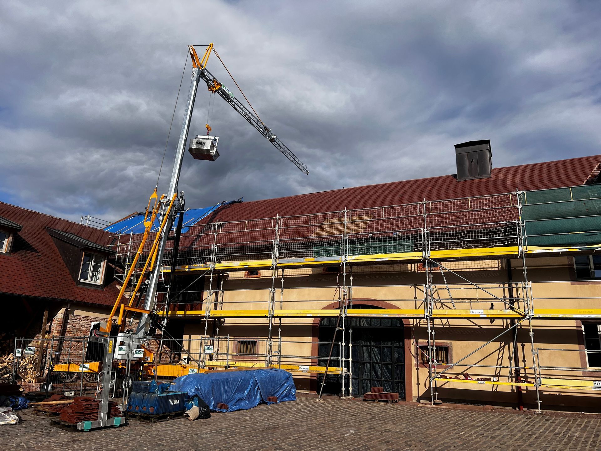 Grue dépliée au dessus du toit d'une grande maison ancienne