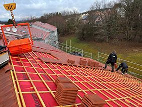 Travaux de rénovation de toiture à l'aide d'une grue