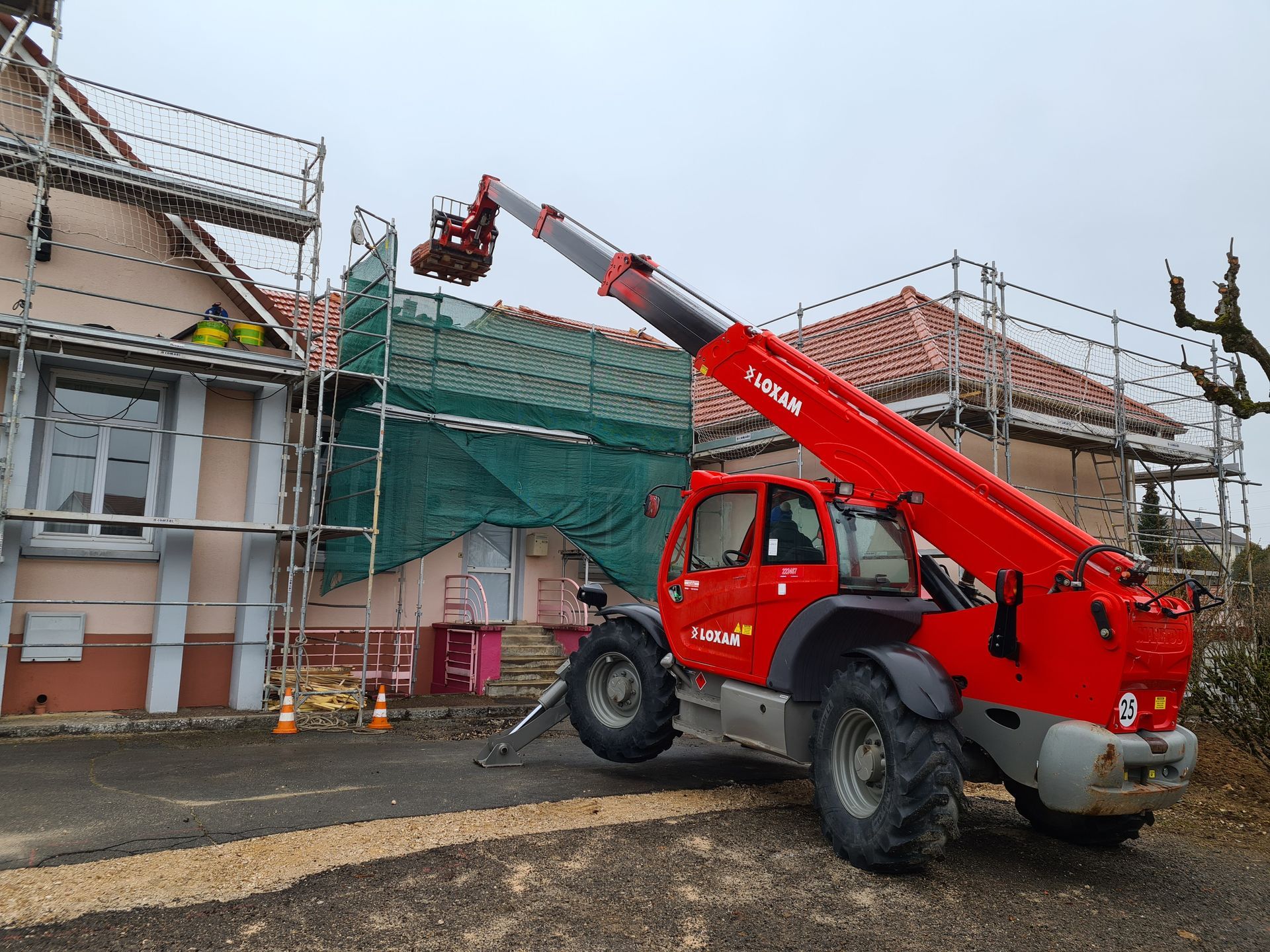 Manitou avec bras déplié au dessus d'une toiture