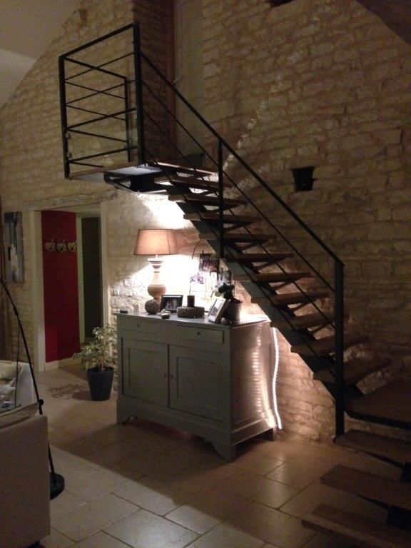 Meuble avec lampe allumée sous un escalier en bois