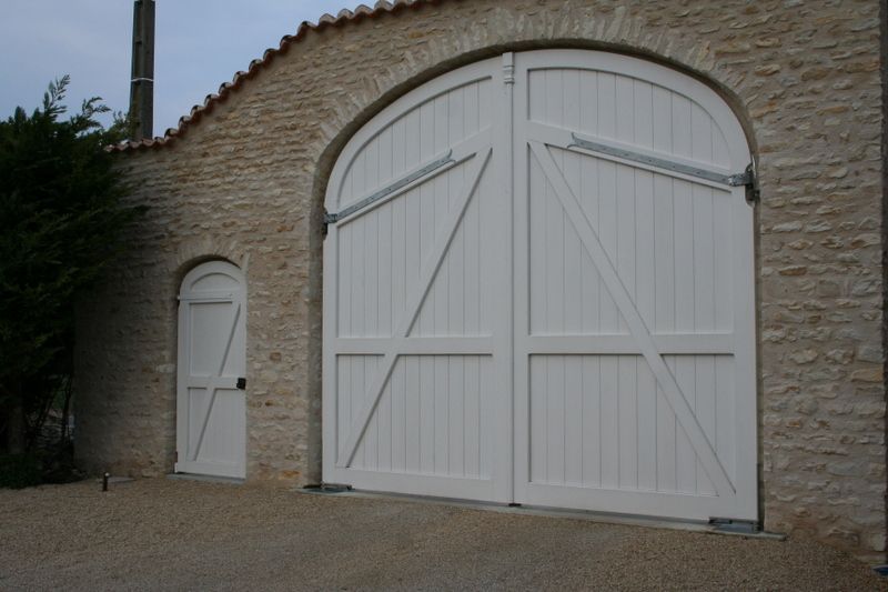Grand portail en arche blanc avec petite porte à coté