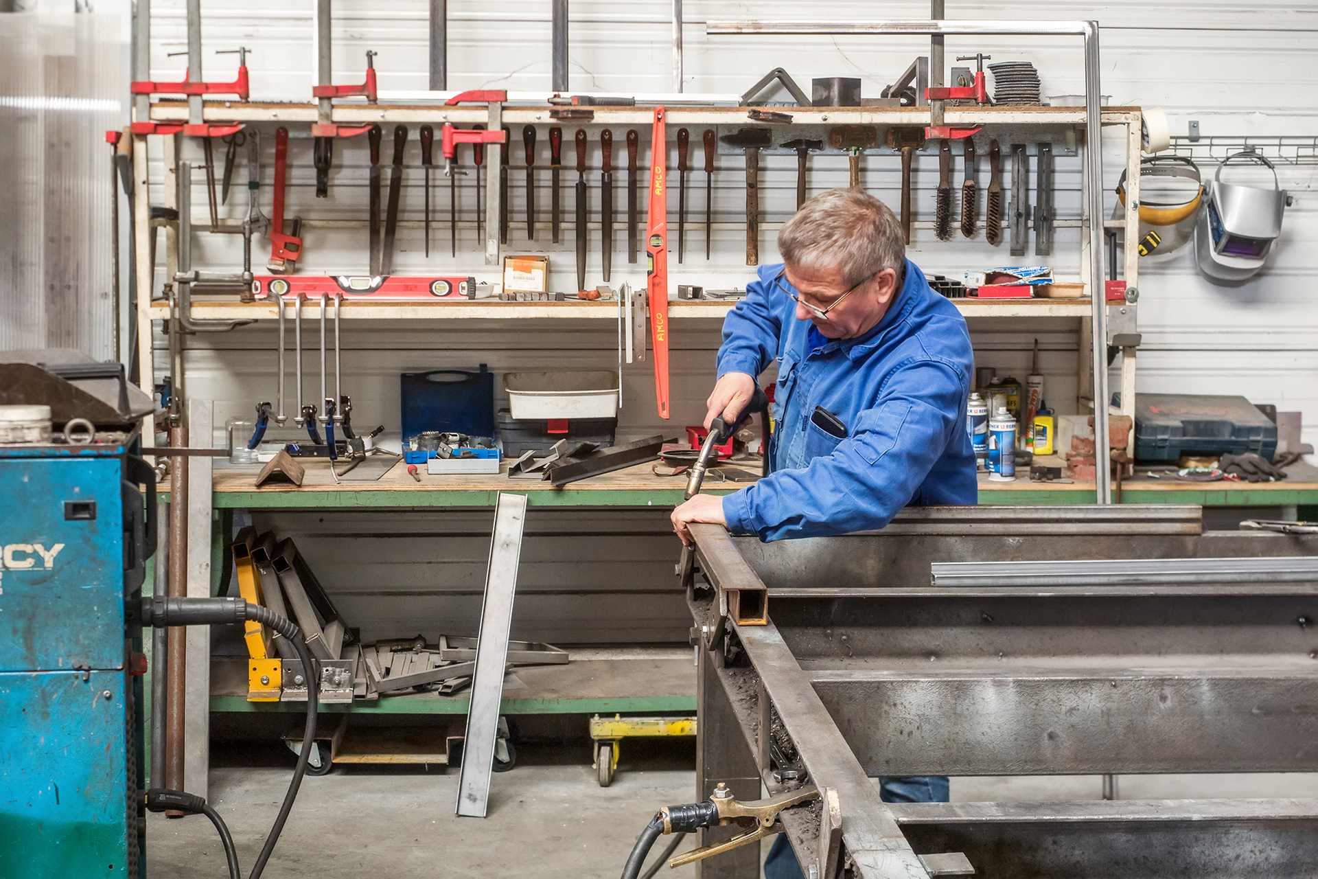 Professionnel d'AMCO CREATECH faisant des réparations sur la structure d'un ascenseurs en atelier
