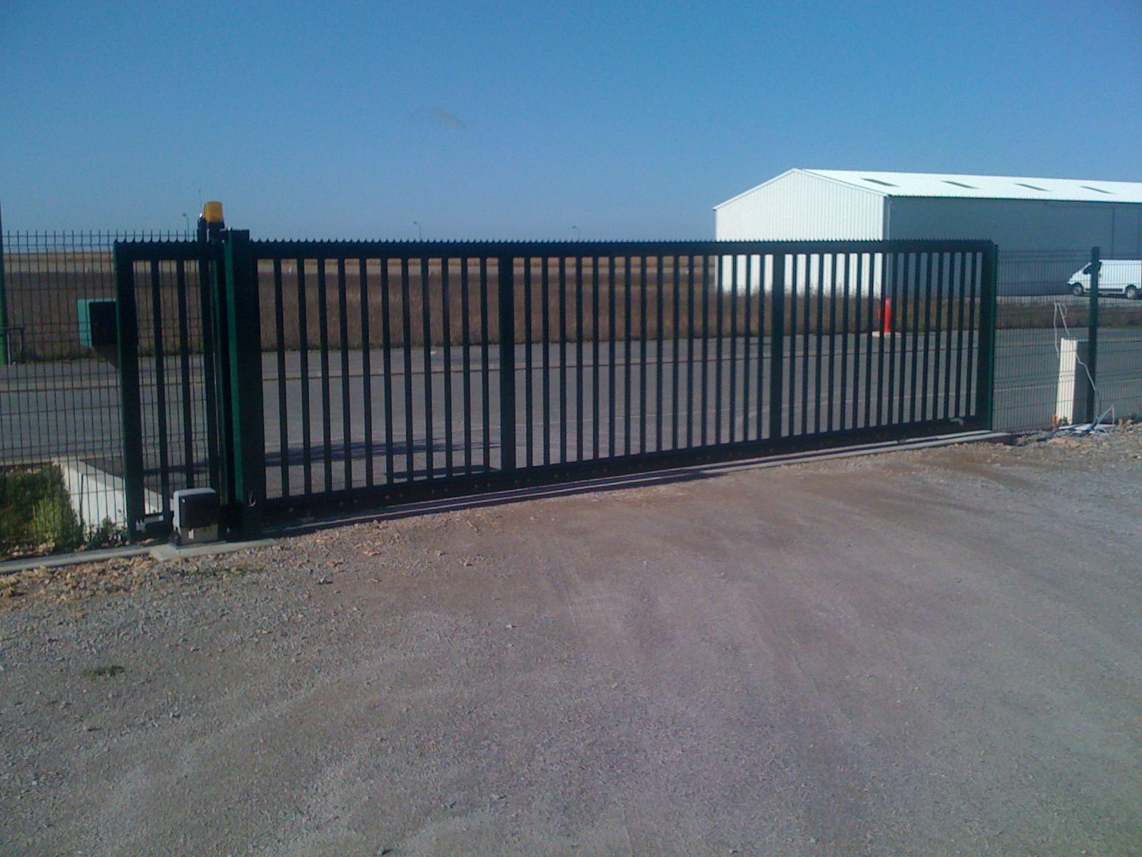 Barrière coulissante verte devant une route