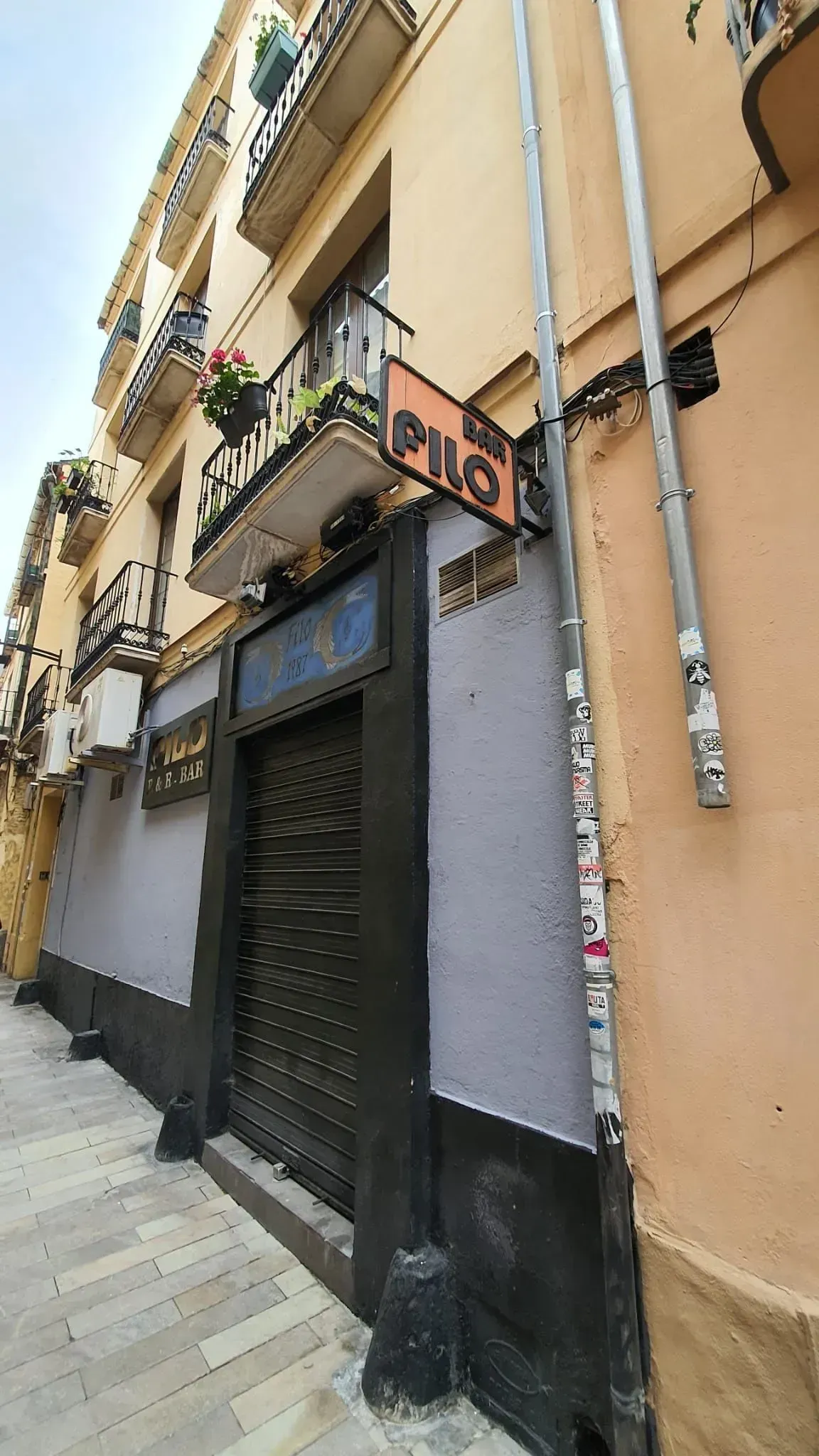 Exterior de un edificio con una puerta negra y un letrero 
