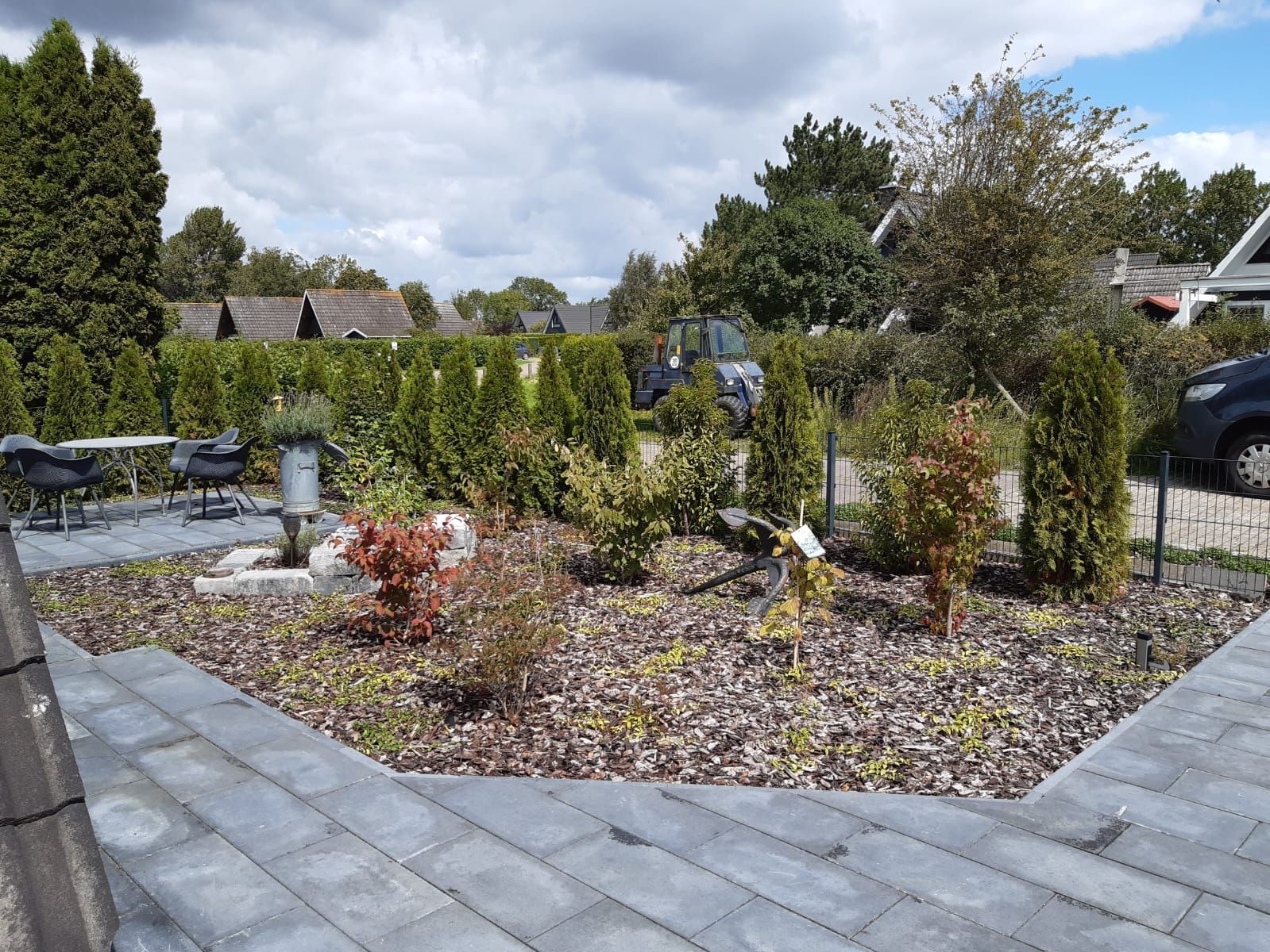 Eine Terrasse mit einem geparkten Auto im Hintergrund