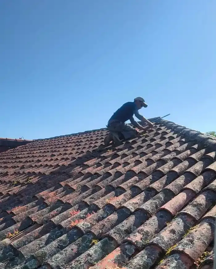Hombre en la cocina instalando armarios, con cinturón de herramientas. Armarios de madera, pared de ladrillo blanco.