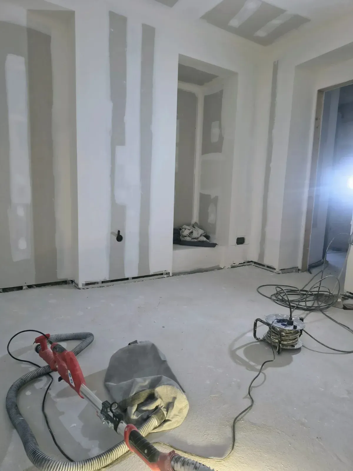 Habitación interior en construcción con estructura de madera vista y grandes ventanales.