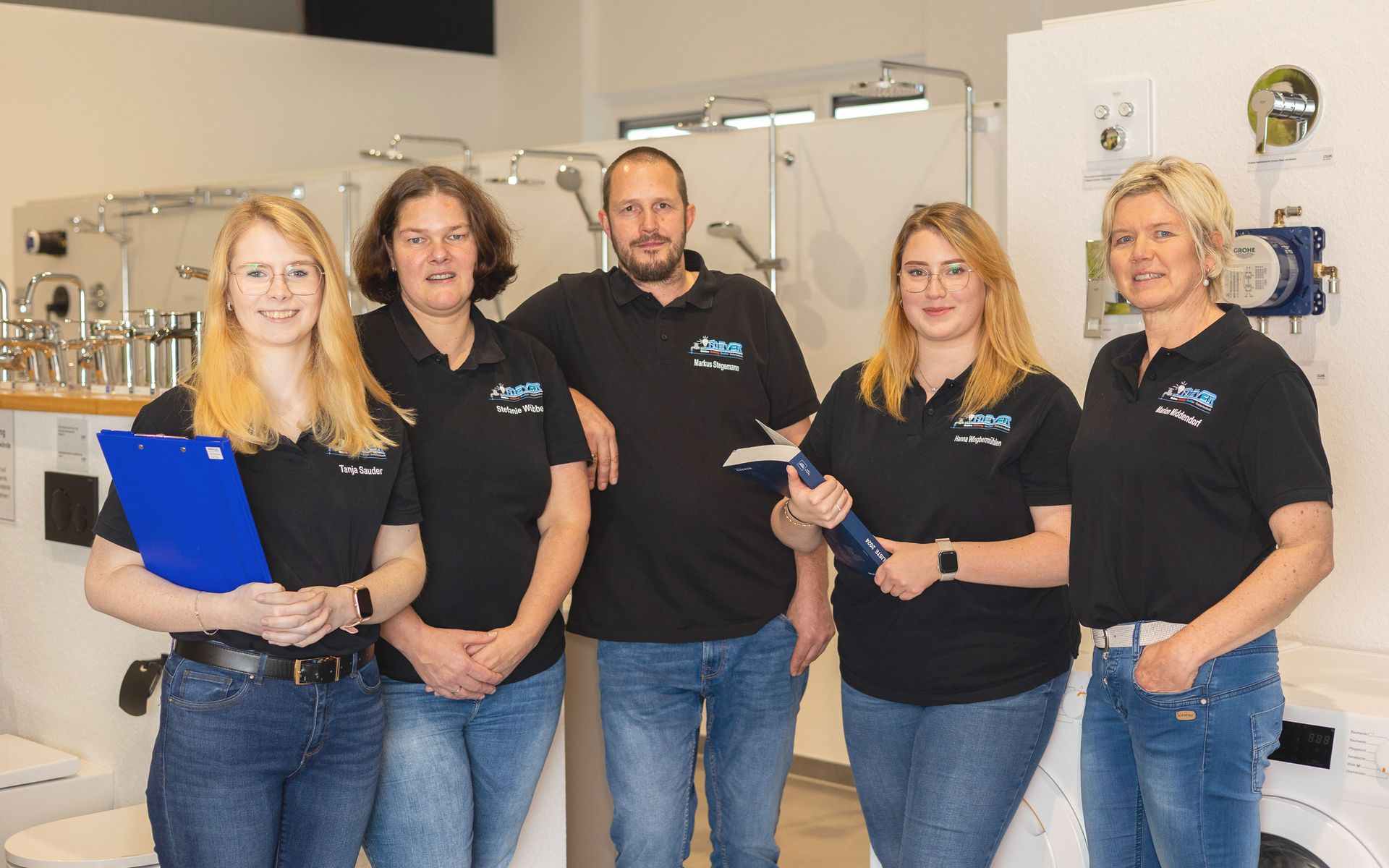 Drei Frauen stehen nebeneinander in einem Büro.