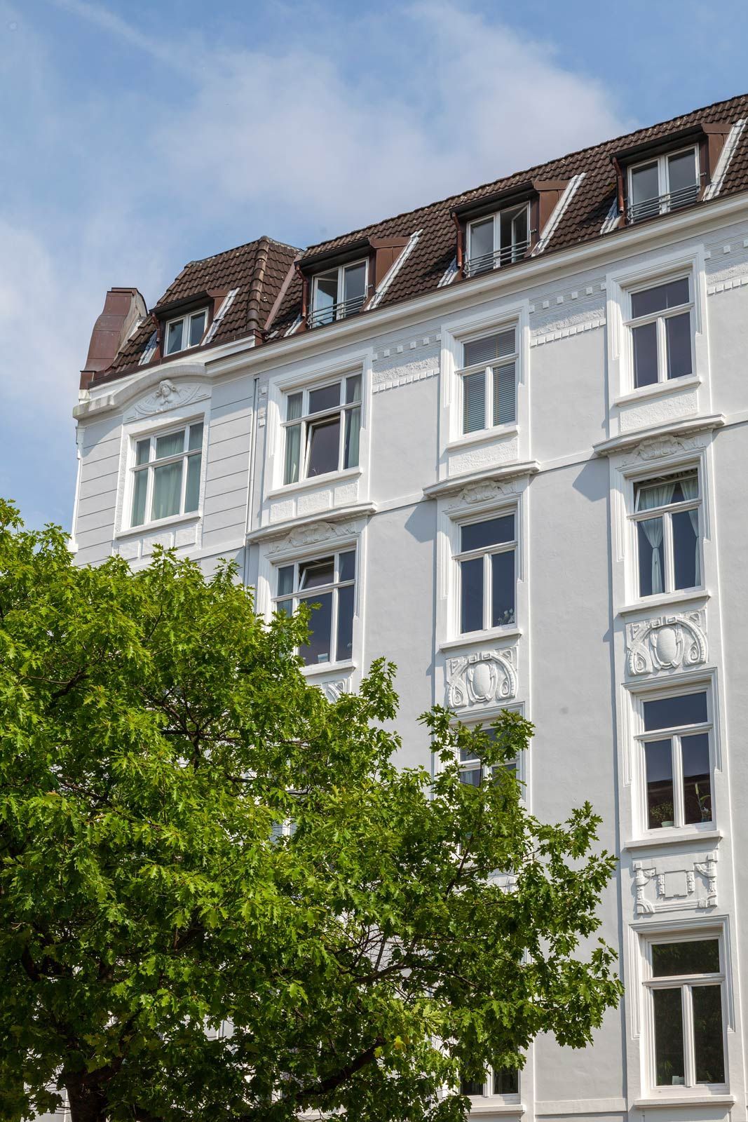 Ein weißes Gebäude mit einem Baum davor