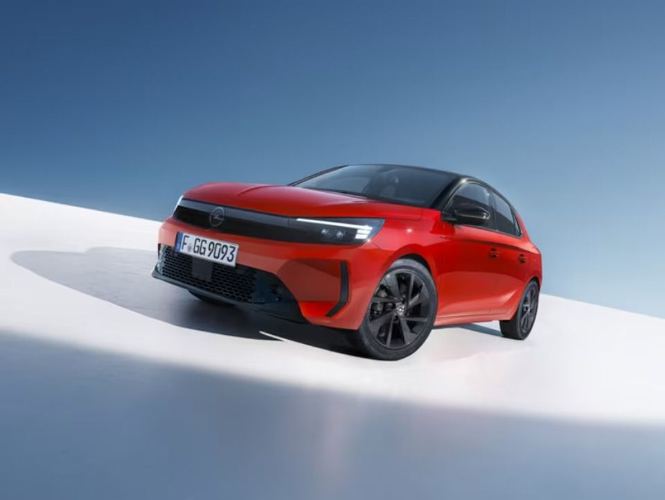 Voiture Opel Astra rouge sur une surface blanche et bleue, vue en angle.