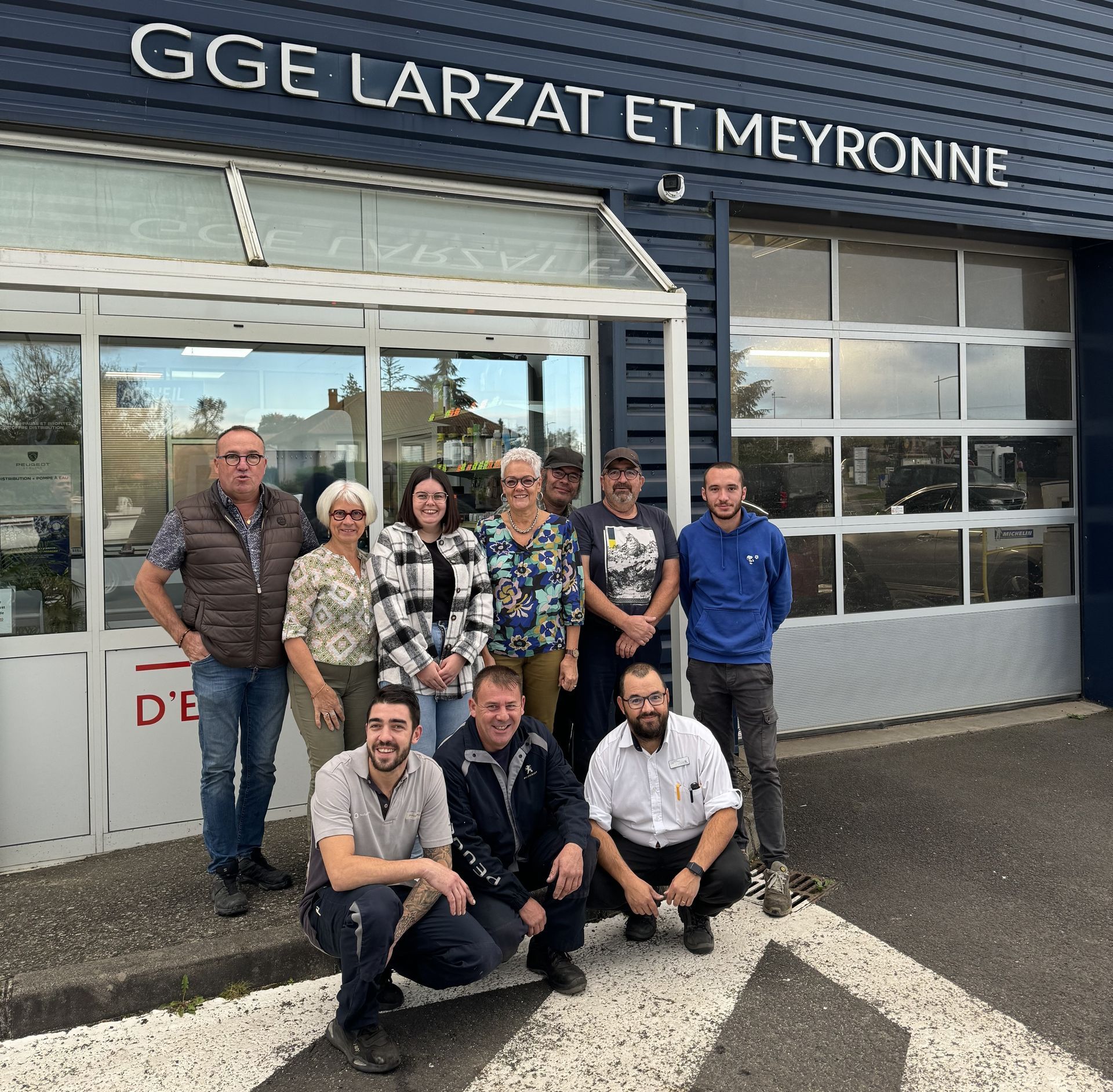 Groupe de personnes souriant devant le garage Larzat et Meyronne