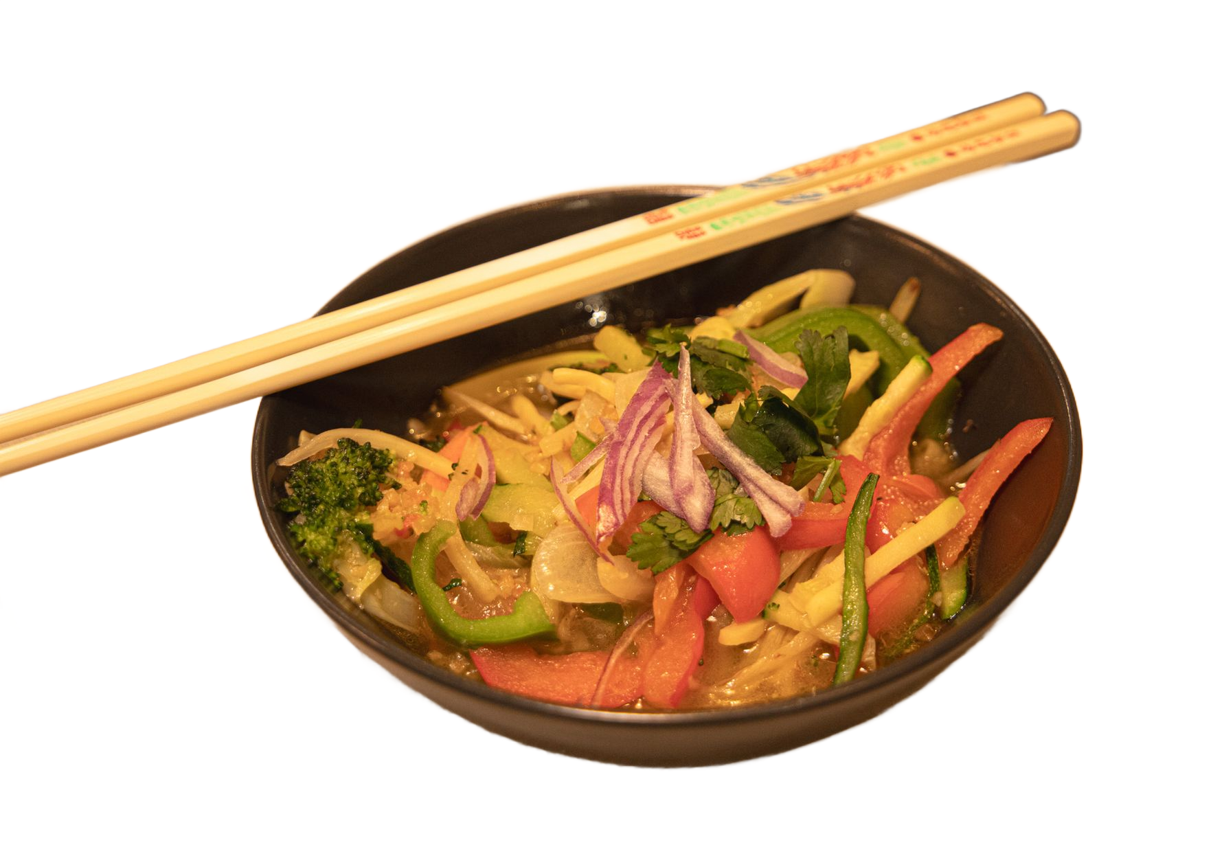 Bol de légumes sautés colorés avec des baguettes posées sur le bord.