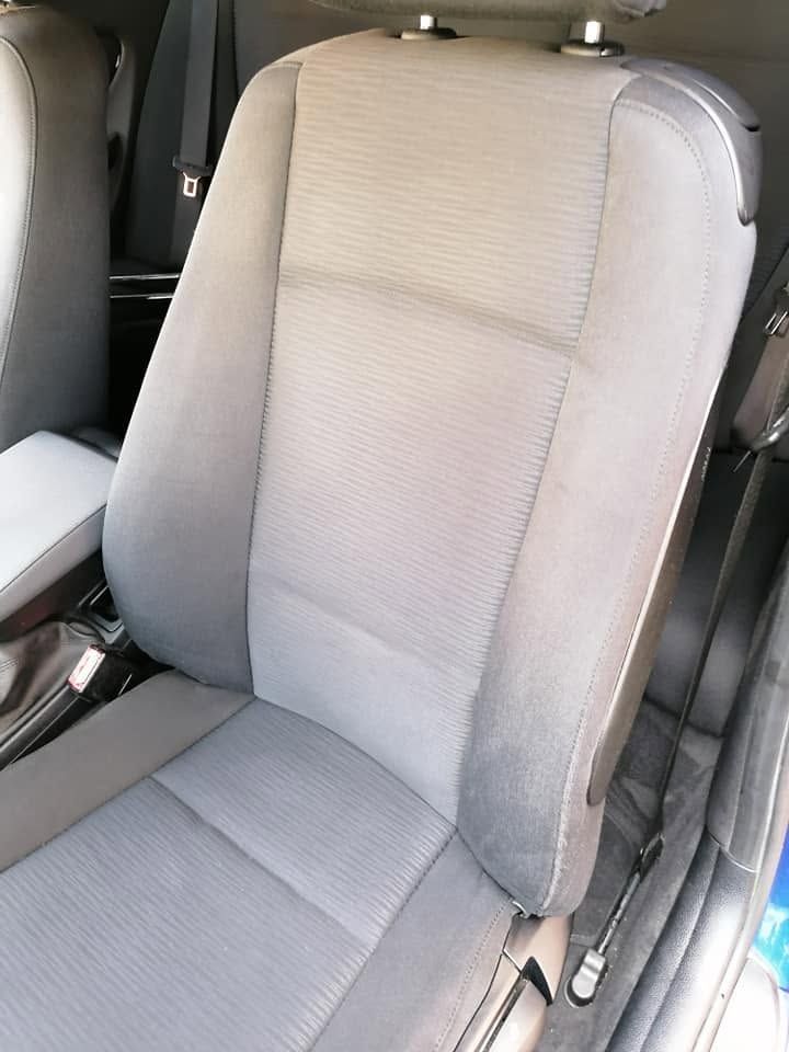 Siège auto gris avec revêtement en tissu clair et appui-tête à l'intérieur d'un véhicule