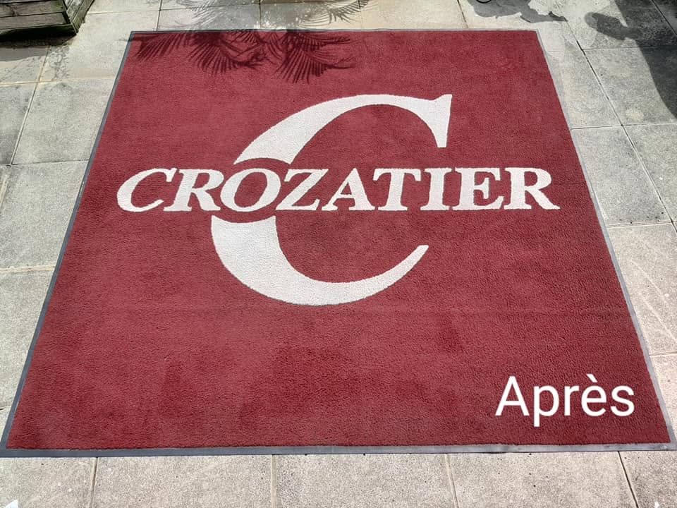Tapis rouge Crozatier avec un grand logo C blanc et le mot Après dans le coin.