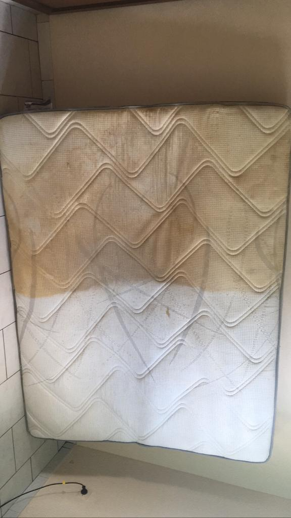 Matelas ou coussin à chevrons beiges et blancs appuyé contre une boîte dans une chambre