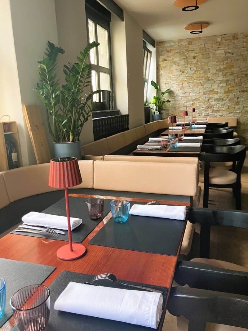 Un restaurant avec des tables et des chaises et une lampe sur la table