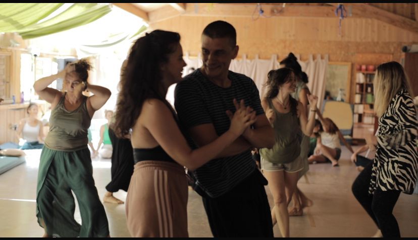 Manos entrelazadas en una imagen grupal borrosa, que sugiere una reunión o un círculo de apoyo.