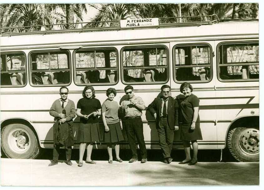 Un grupo de personas de pie delante de un autobús
