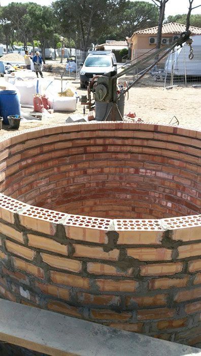Se está construyendo un gran muro de ladrillos en un campo.
