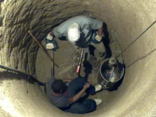Dos hombres están trabajando en un agujero en el suelo.