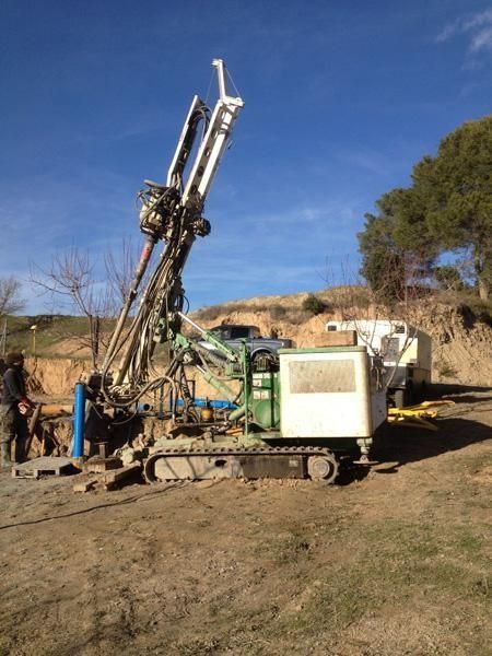 Una gran máquina está sentada encima de un campo de tierra.