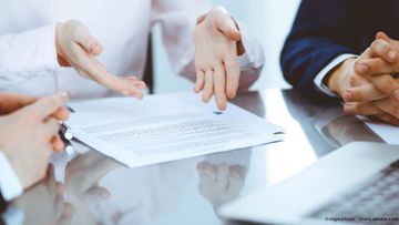 Sigrid Balders Rechtsanwältin Drei Personen schauen auf und diskutieren über ein Dokument