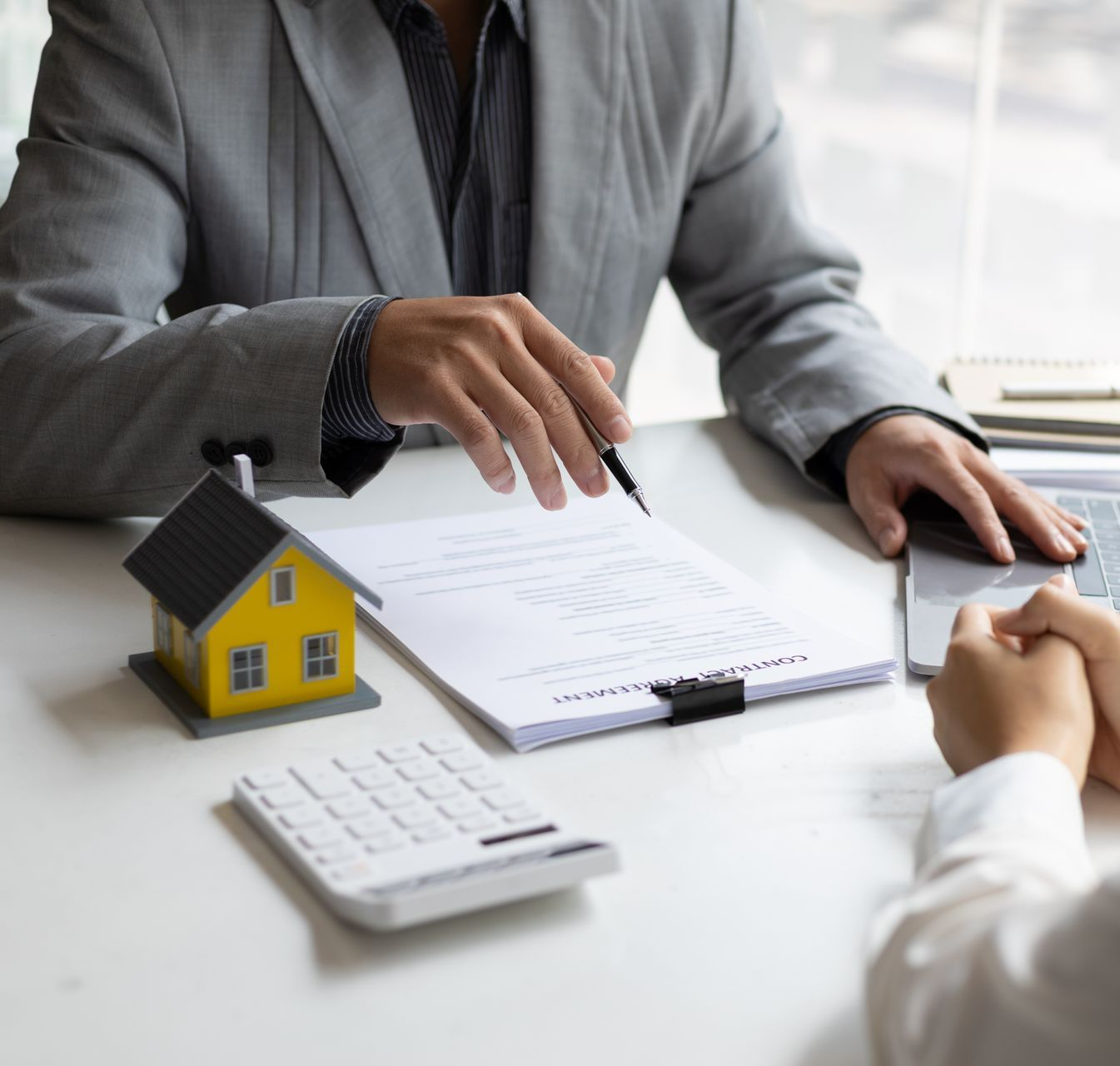 Homme en costume tenant un stylo pour signer
